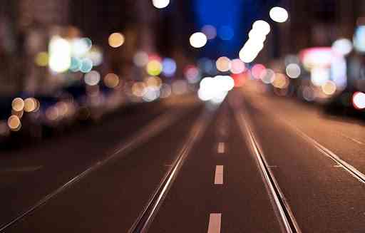 Carretera nocturna y iluminada por las luces de la calle.